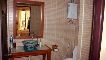 Ein Badezimmer mit Waschbecken, Spiegel und Toilette.