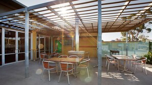 An outdoor patio with tables and chairs, a covered seating area, and a view of the surrounding area. - Nightcap at St Albans Hotel (St. Albans)