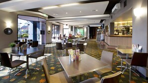 A hotel lobby with multiple seating areas, a reception desk, and a bar. - Nightcap at St Albans Hotel (St. Albans)