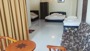 Een hotelkamer met een bed, een bank, een houten tafel en een kledingkast.