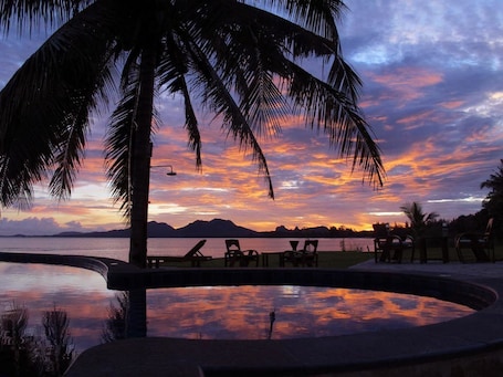 Una piscina al aire libre, sombrillas, sillones reclinables de piscina