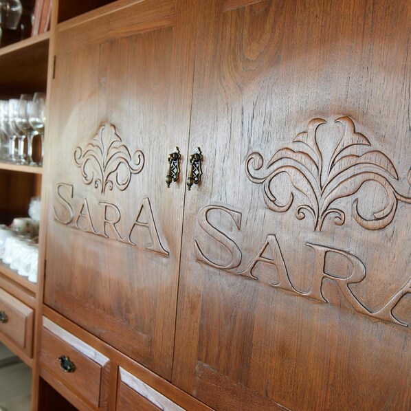 A wooden cabinet with the name 'SARA' carved into it. - Sara Beachfront Boutique Resort (Pathio)