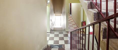 A staircase with a checkered floor leading to a landing.