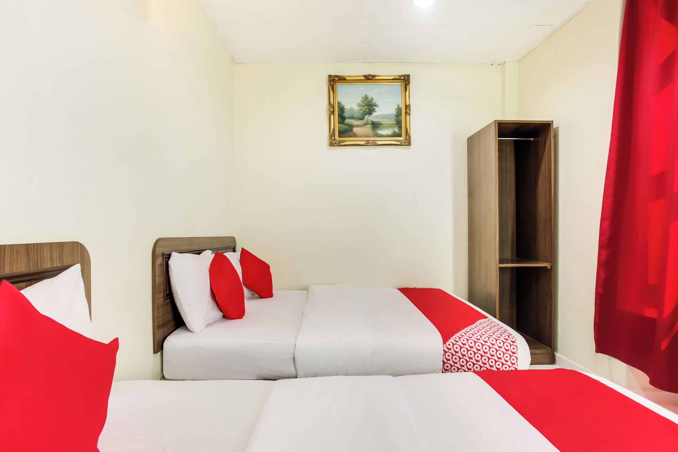 Une chambre d’hôtel avec un lit, une armoire et un tableau au mur.