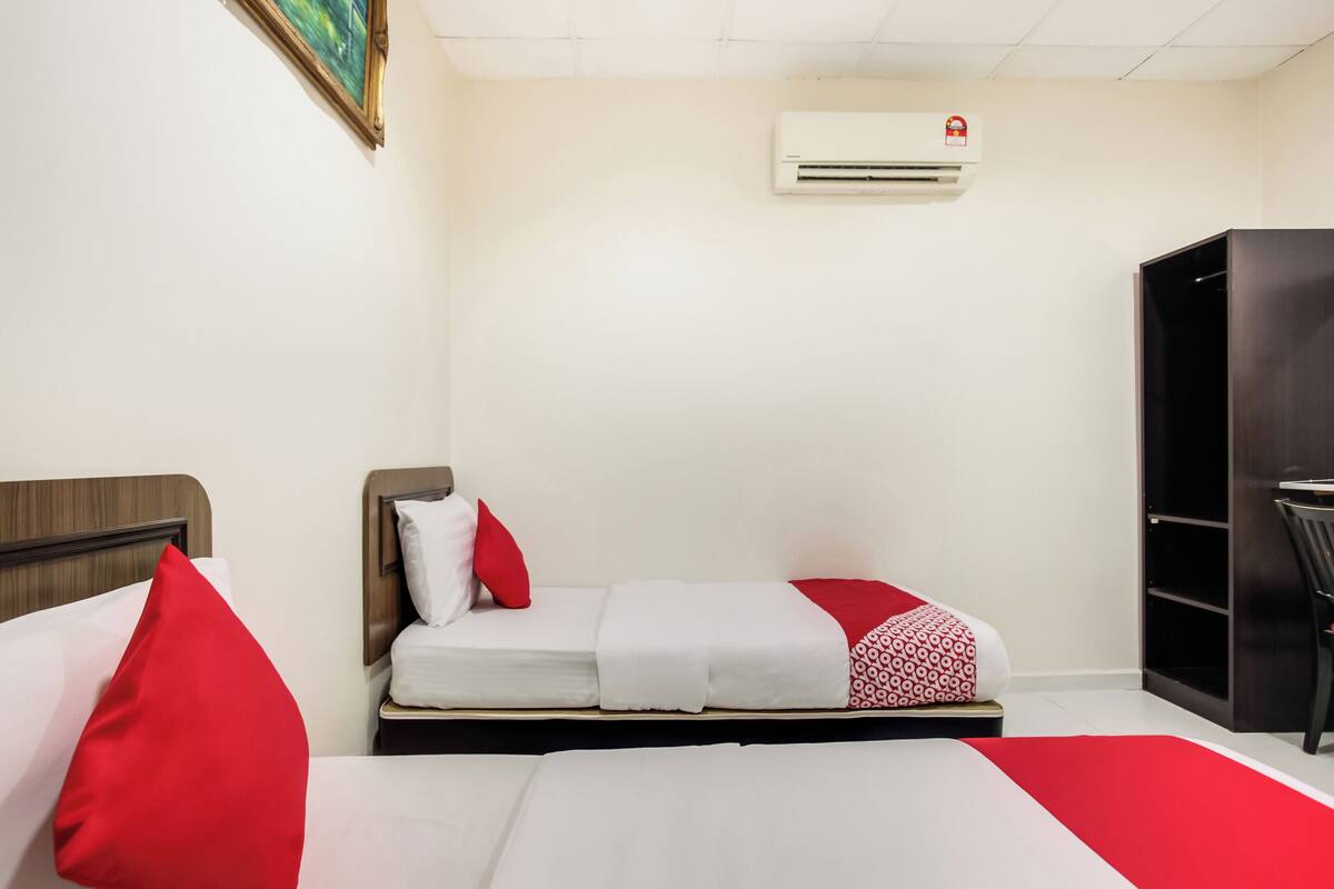 Een hotelkamer met twee bedden, een kledingkast en een bureau.