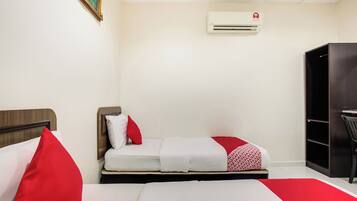 Habitación de hotel con dos camas, un armario y un escritorio.
