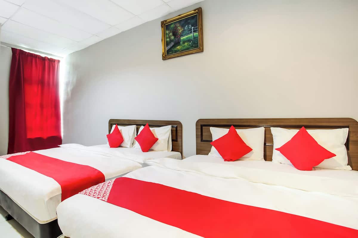 Een hotelkamer met twee bedden, elk voorzien van witte beddengoed en rode accenten, een houten hoofdeinde en een schilderij aan de muur.