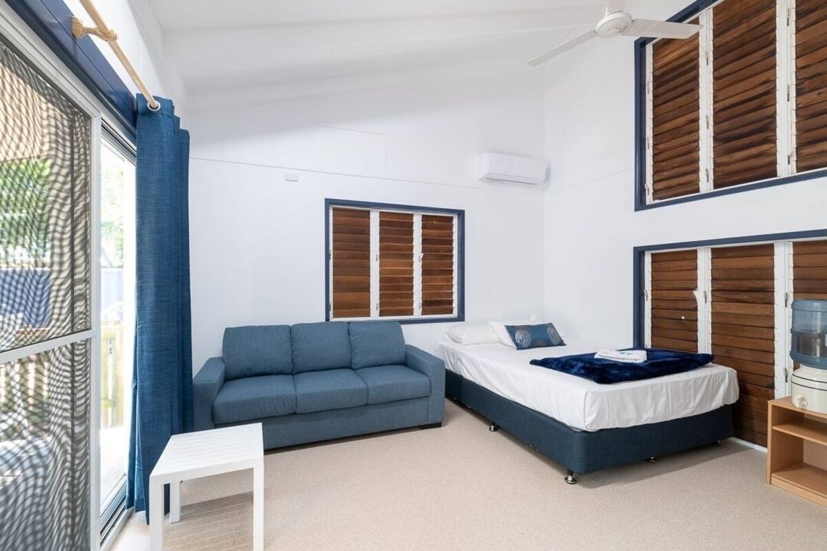 Un dormitorio moderno con cama, sofá y una mesita.