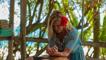 Guests can enjoy a rejuvenating massage in a serene outdoor setting surrounded by lush greenery.