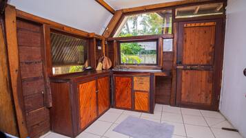 A kitchen with wooden cabinets, a sink, and a window overlooking a garden.