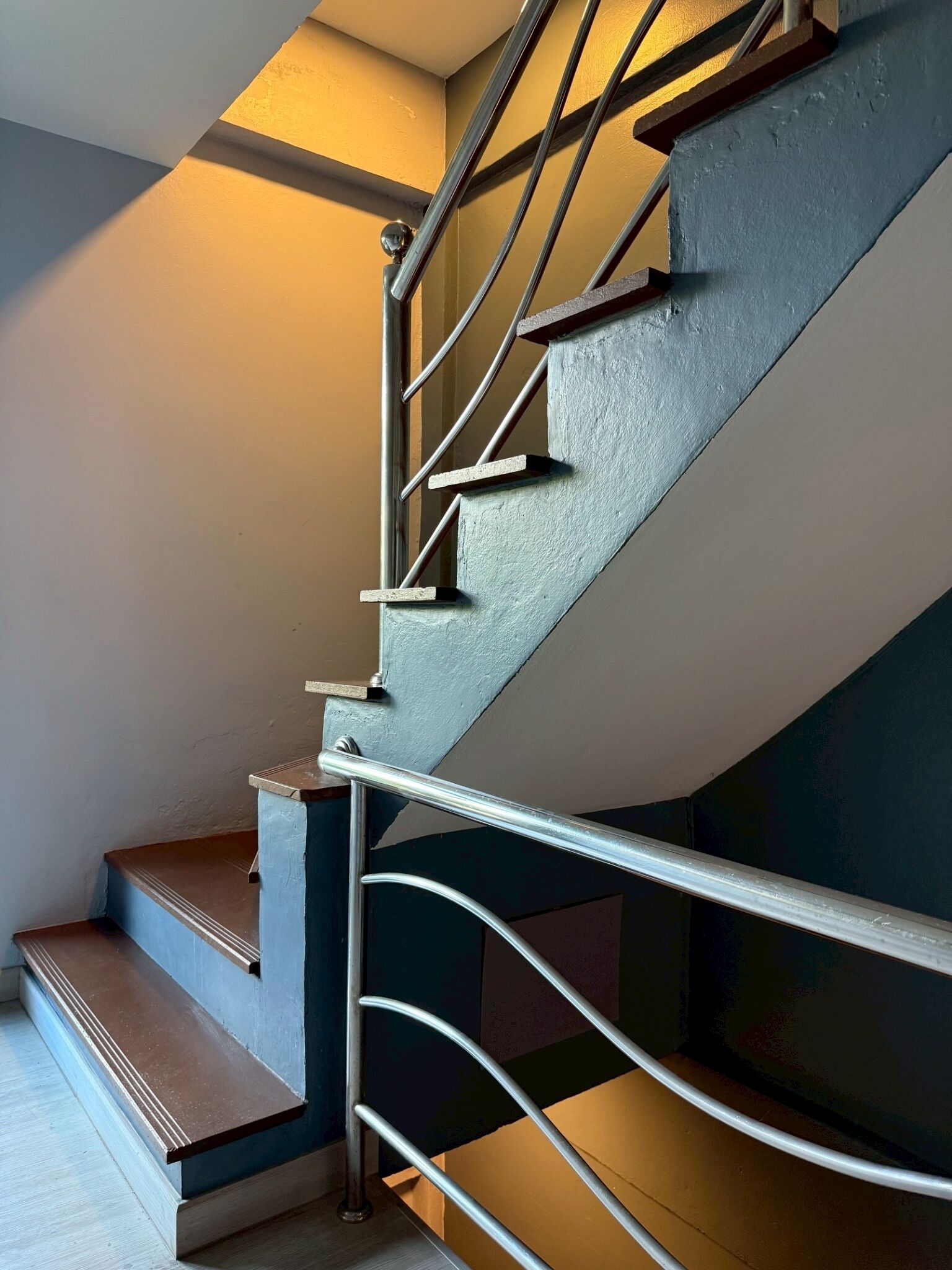 Un escalier moderne avec des rampes en métal et des marches en bois.