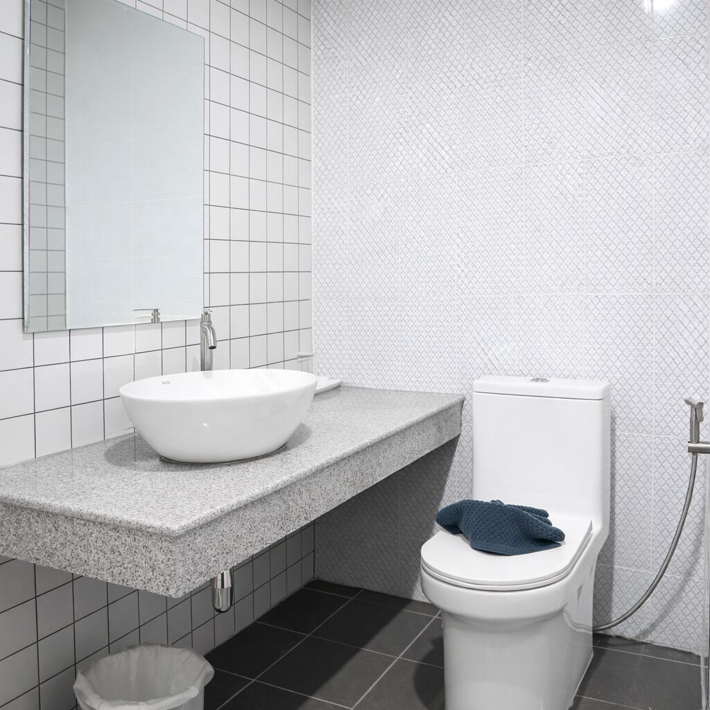 A bathroom with a white sink, a toilet, and a shower area.