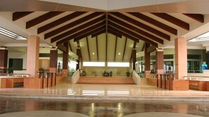 A spacious lobby with a high ceiling, a central staircase, and a modern design. - Uniland Golf & Resort (Nakhon Pathom)