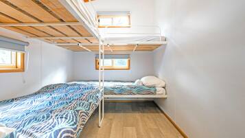 Un dormitorio con literas, una ventana y una colcha estampada.