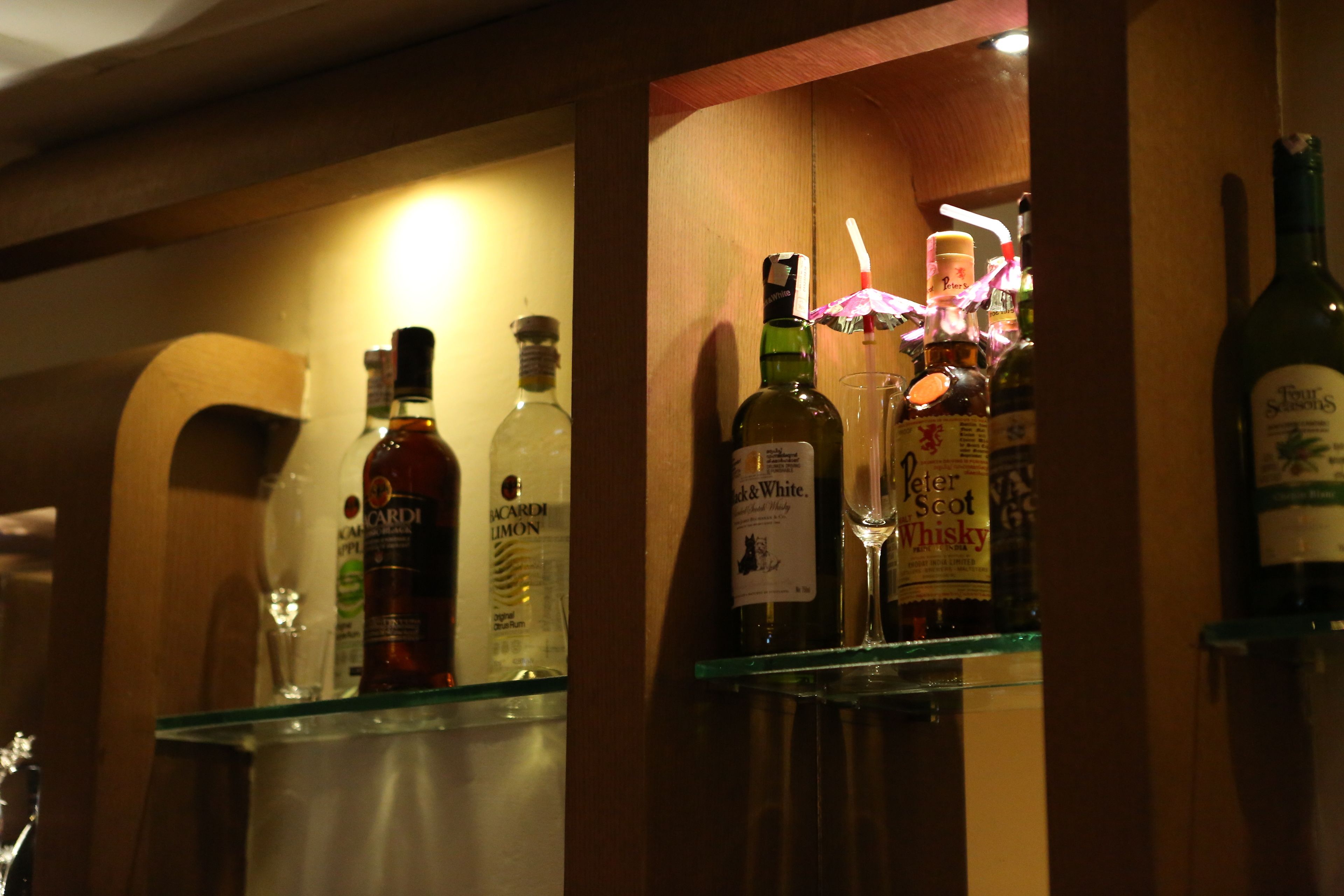 Zona de bar con varias botellas y vasos.