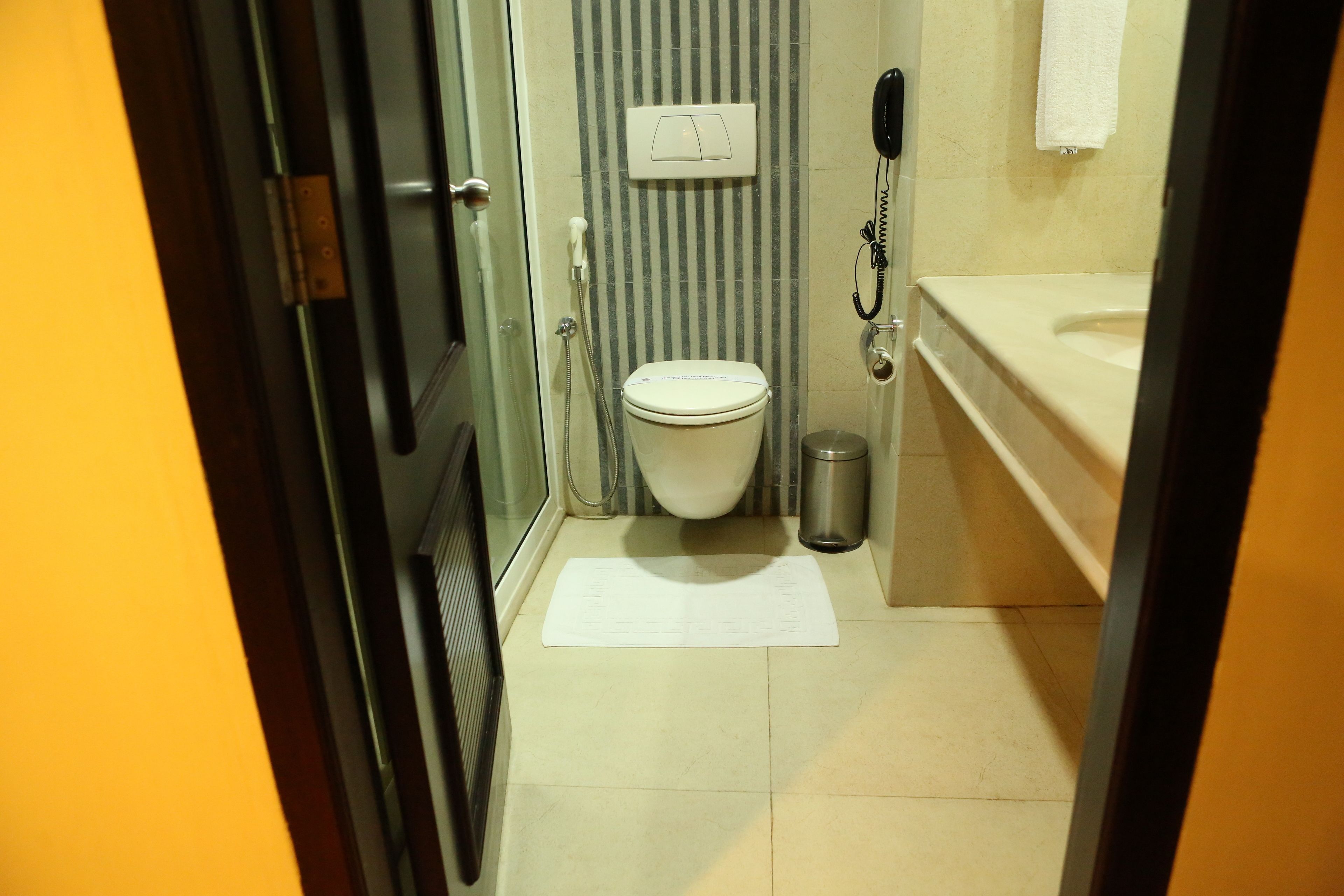 Un baño pequeño y funcional con inodoro, lavamanos y ducha.