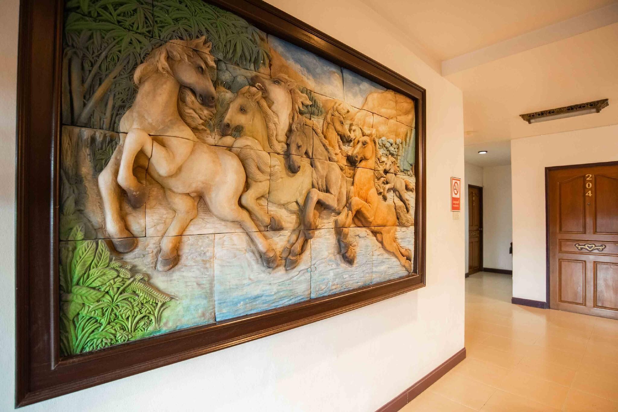Un pasillo con un gran mural de caballos y follaje.