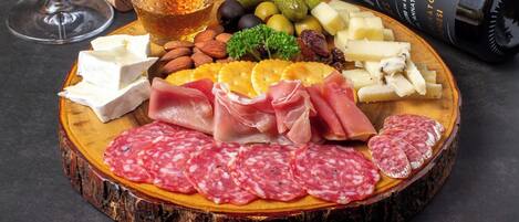A charcuterie board with various meats, cheeses, nuts, and olives.