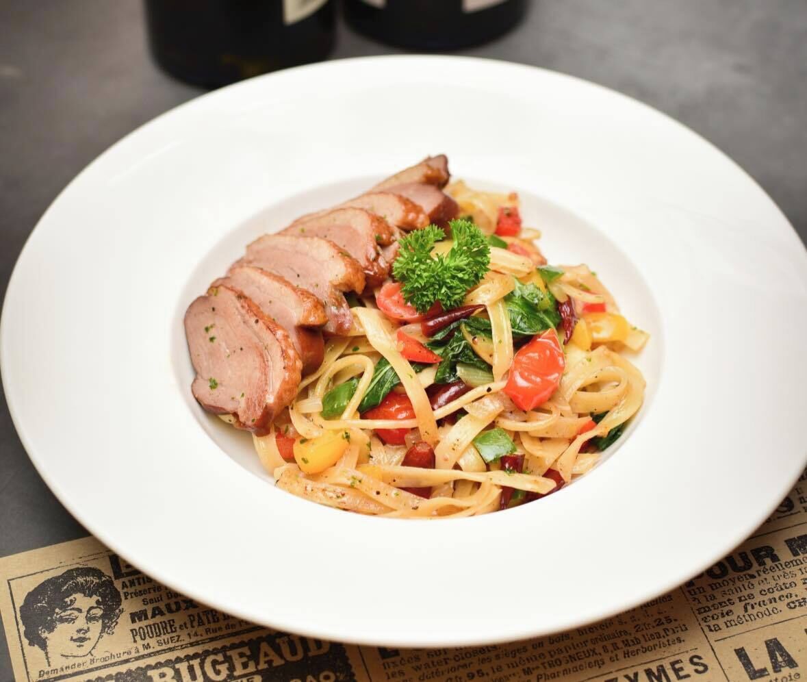 A plate of pasta with meat and vegetables.