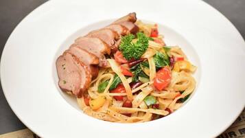 A plate of pasta with meat and vegetables.
