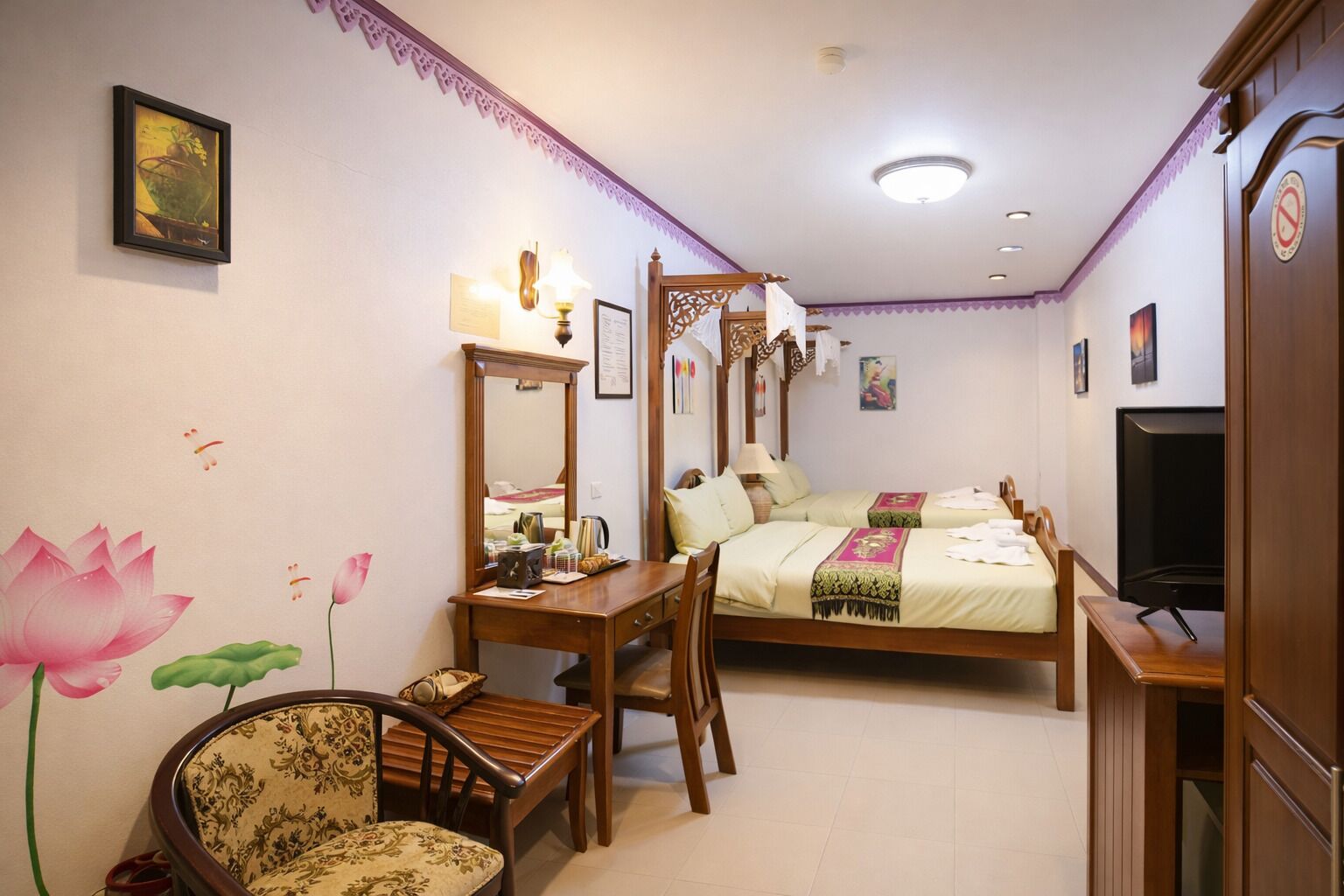 Une chambre d’hôtel avec un lit à baldaquin, un bureau avec un miroir, une chaise et un téléviseur.