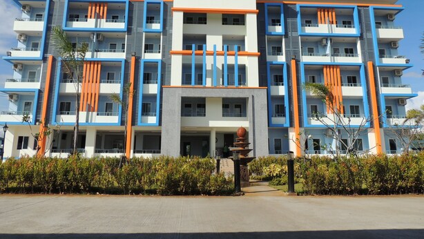 A multi-story hotel with a modern architectural design, featuring balconies and a central entrance. - Trang Grand Mansion (Trang)