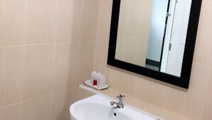 A bathroom with a white sink, a mirror, and a towel rack. - Trang Grand Mansion (Trang)