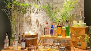 Een bar met verschillende drankflessen, glazen en een houten toog.