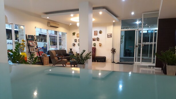 A spacious lobby with a modern design, featuring a seating area with a sofa and armchairs, a fan, and potted plants. - S2S Queen Trang Hotel (Trang)