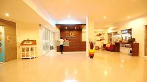 A hotel lobby with a reception desk, a staircase, and a seating area. - S2S Queen Trang Hotel (Trang)