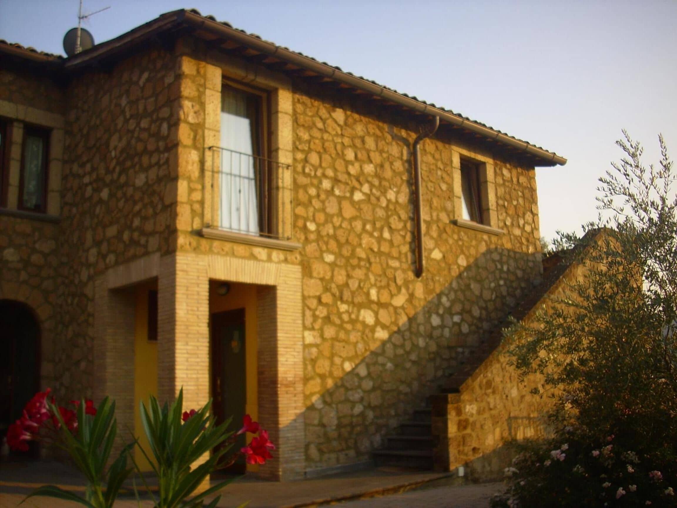 A stone building with a staircase leading to a door.