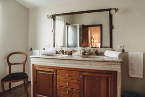 A bathroom with a wooden vanity, two sinks, a mirror, and a chair. - Masseria Ciavolich (Loreto Aprutino)