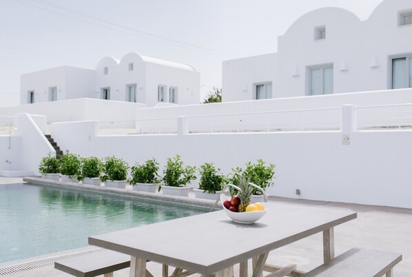 En säsongsöppen utomhuspool, parasoller och solstolar