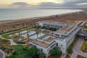 A modern hotel with a rooftop pool, a beach view, and a well-maintained garden. - Pestana Alvor South Beach, Premium Suite Hotel (PortimĂŁo)