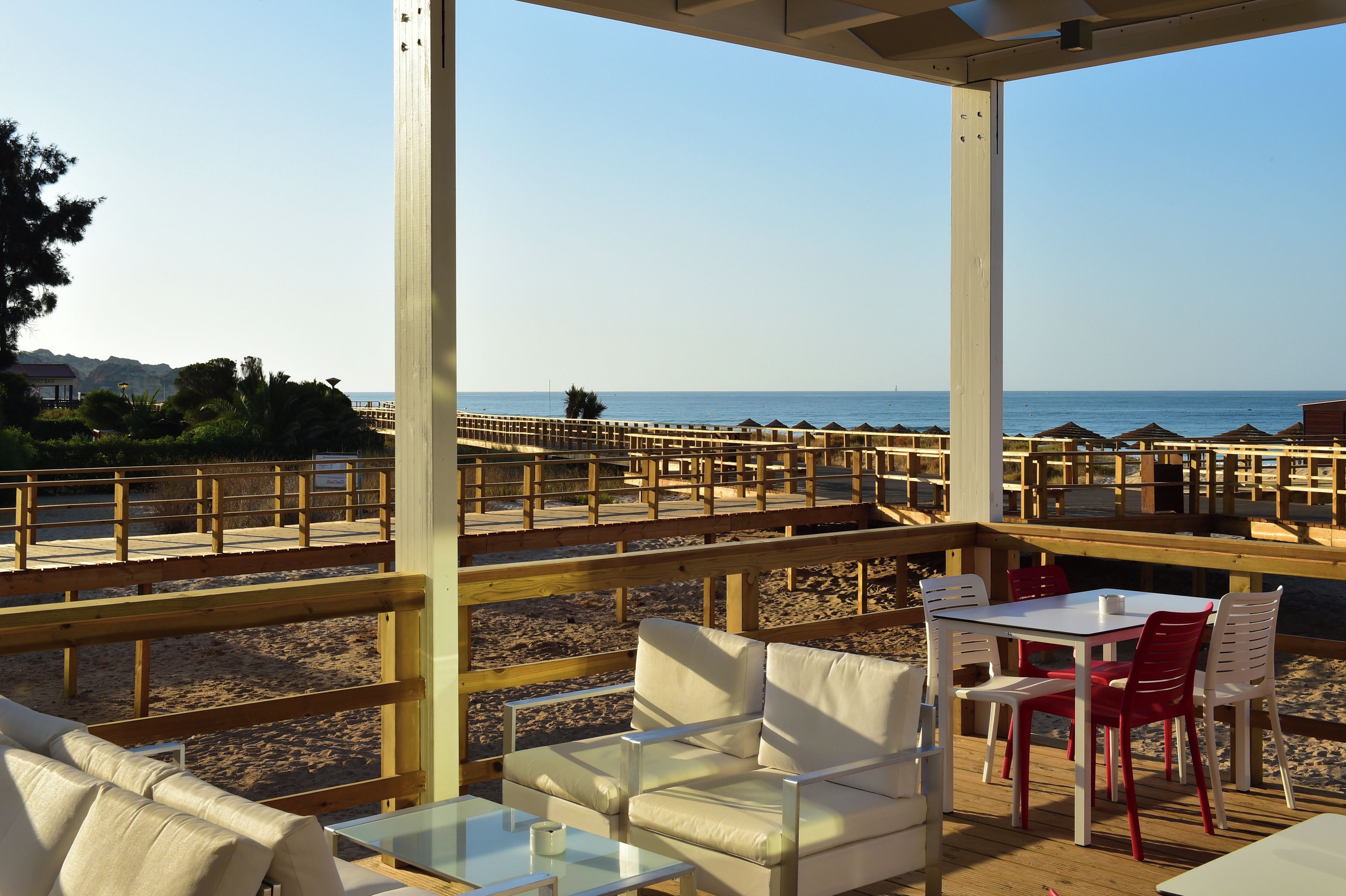 A beachside patio with outdoor seating and a view of the sea.