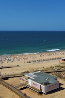 A beach with a lifeguard tower, a boardwalk, and a building with 'LOVE' written on it.