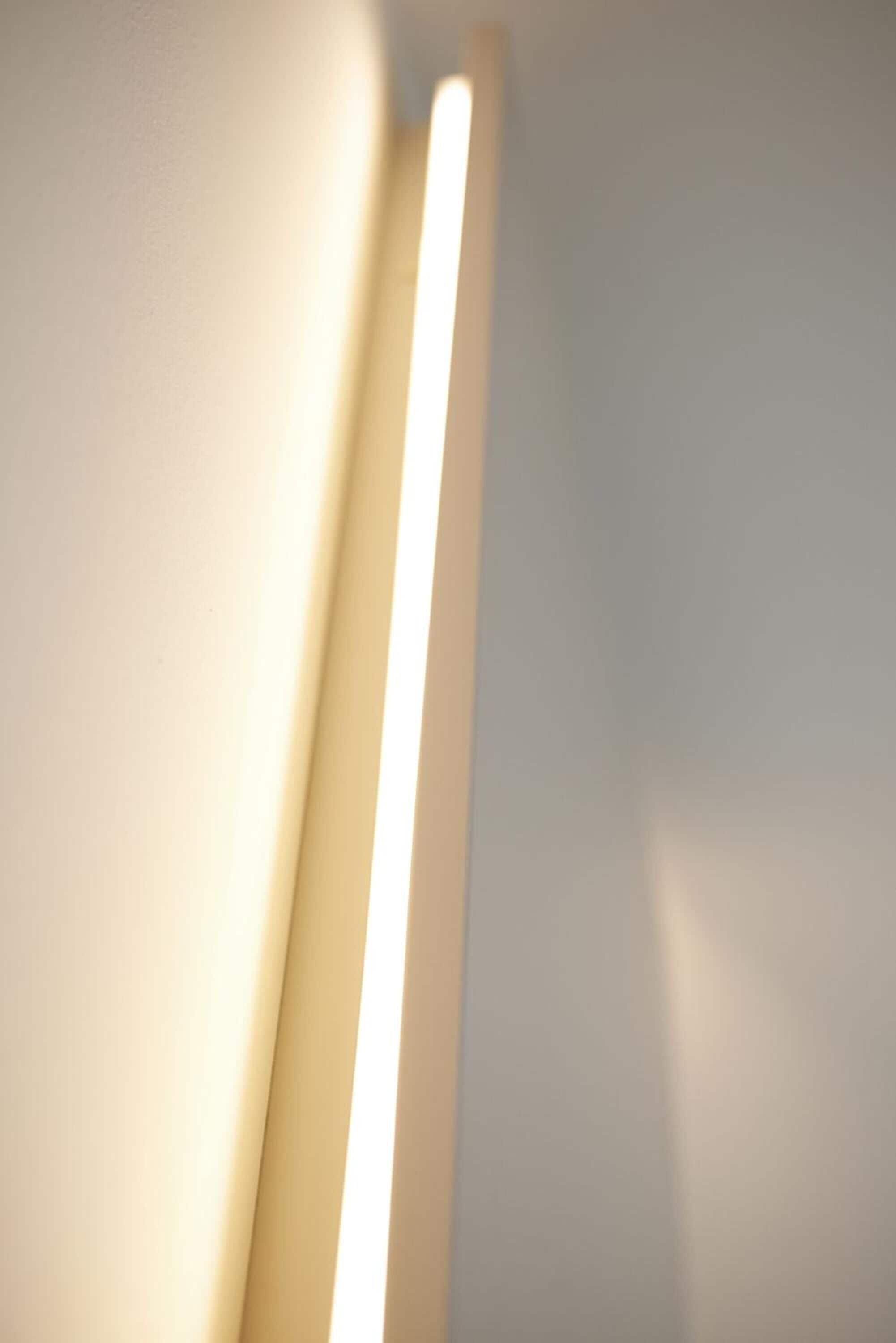Primer plano de una lámpara frente a una pared lisa.