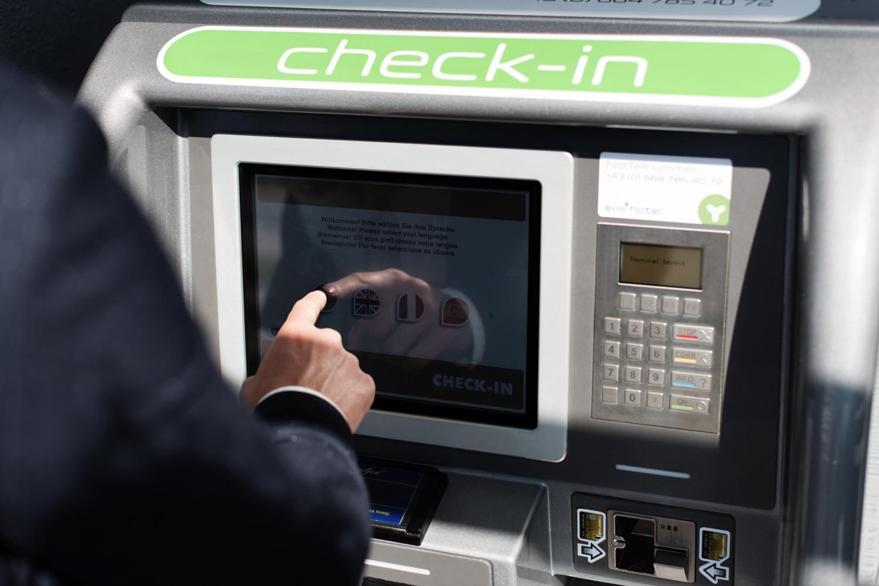 A check-in kiosk with a touchscreen interface, a keypad, and card reader slots.