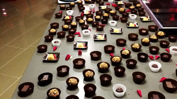 A long table with various chocolates and desserts arranged on it.