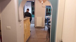 A narrow hallway with a stone counter and a person in the background. - Hostel Melting Pot Rome (Rome)