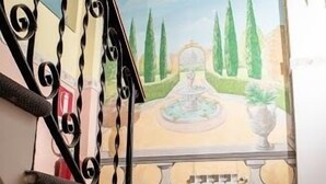A staircase with a decorative railing and a mural of a garden scene. - Hostel Melting Pot Rome (Rome)