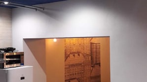 A compact kitchen with a refrigerator, microwave, and a small dining table with chairs. - Hostel Melting Pot Rome (Rome)