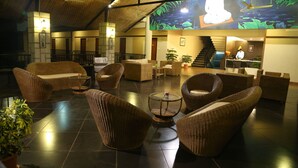 A lobby with wicker furniture, a reception desk, and a staircase.