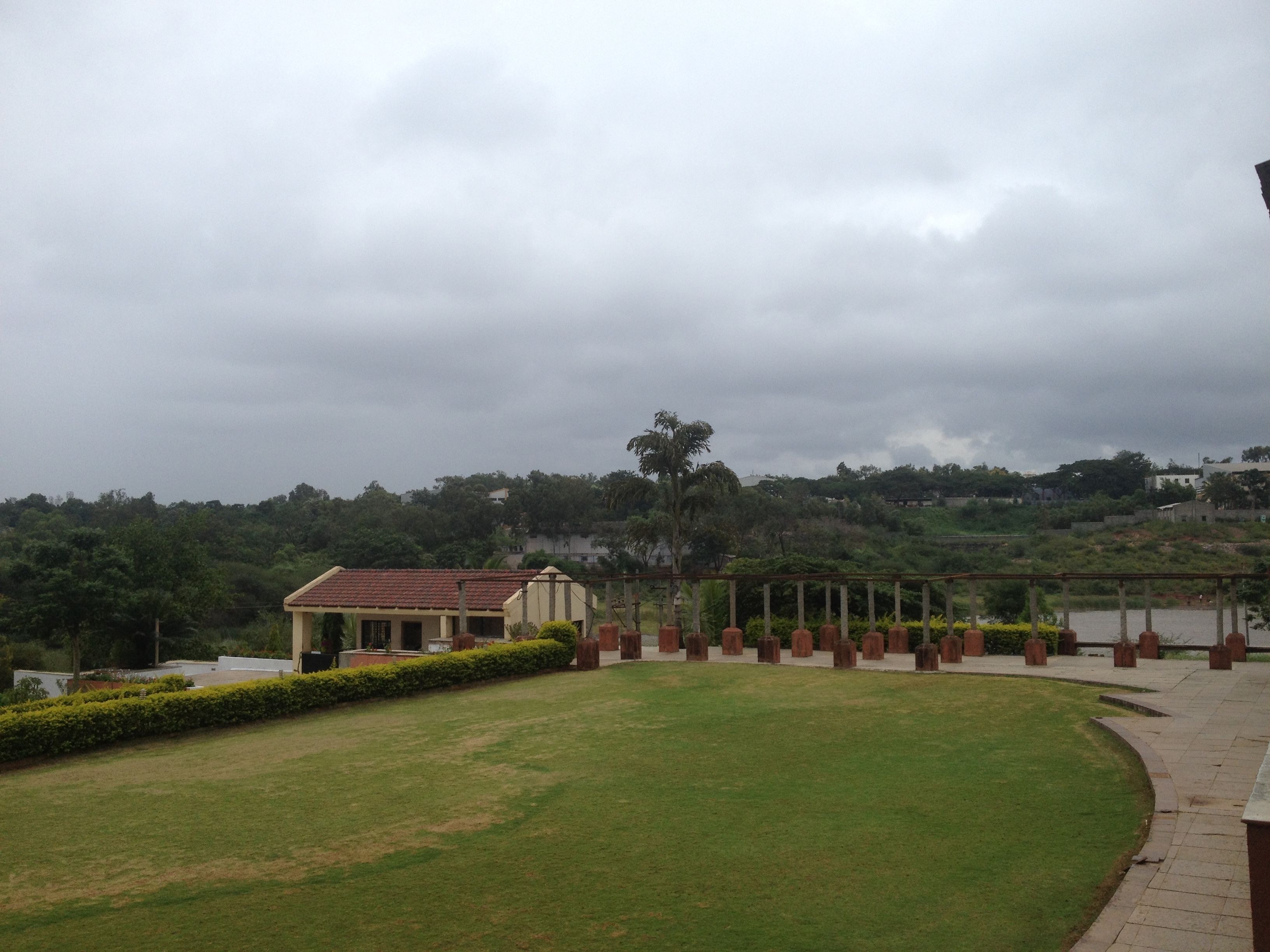 A grassy area with a building and a structure with columns.