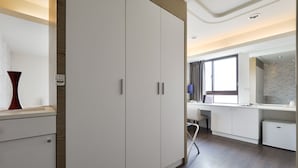A modern hotel room with a large wardrobe, a desk with a chair, and a large window. - Taichung Saint Hotel (Taichung)