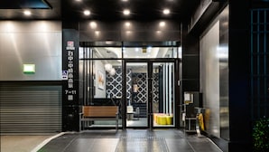 A modern hotel entrance with a glass door, a bench outside, and a wheelchair-accessible sign. - Taichung Saint Hotel (Taichung)
