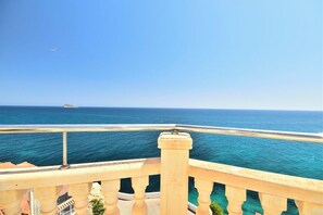 Varanda com vista para o oceano e céu claro.