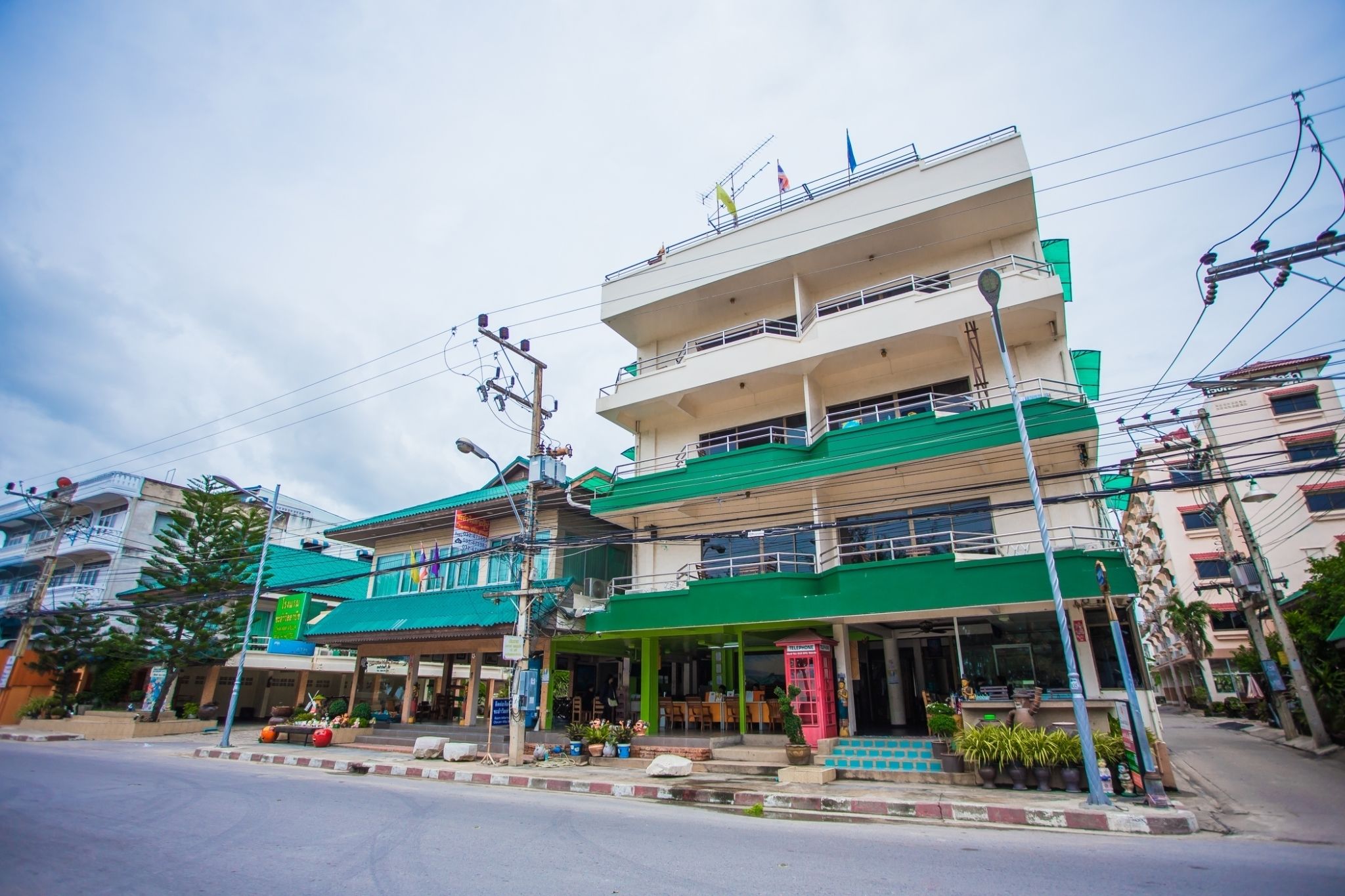 A multi-story building with a green facade and multiple balconies.