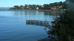 A calm lake with a wooden pier extending into the water. - Agriturismo Da Paola (Manciano)