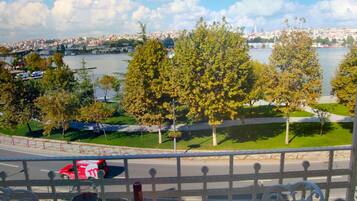 A balcony with a table set for dining, overlooking a river and cityscape.